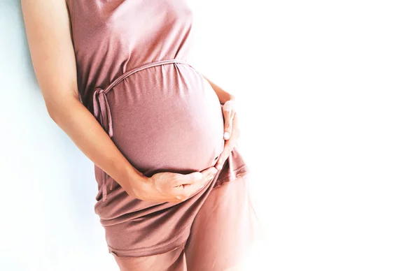 Pregnant woman holds hands on belly. Close-up — Stock Photo, Image