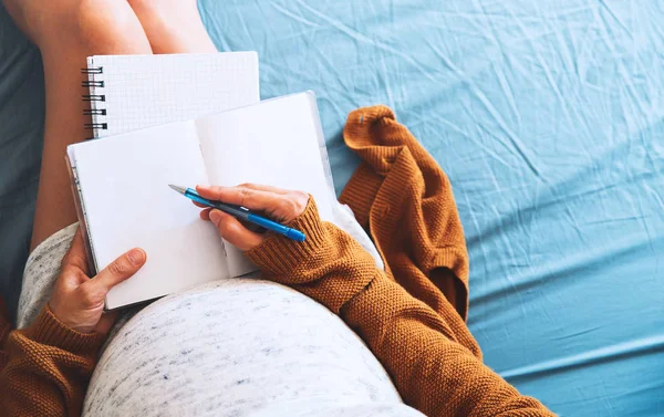 Hamile kadın yapar notları ve tıbbi belgeleri seyir. 