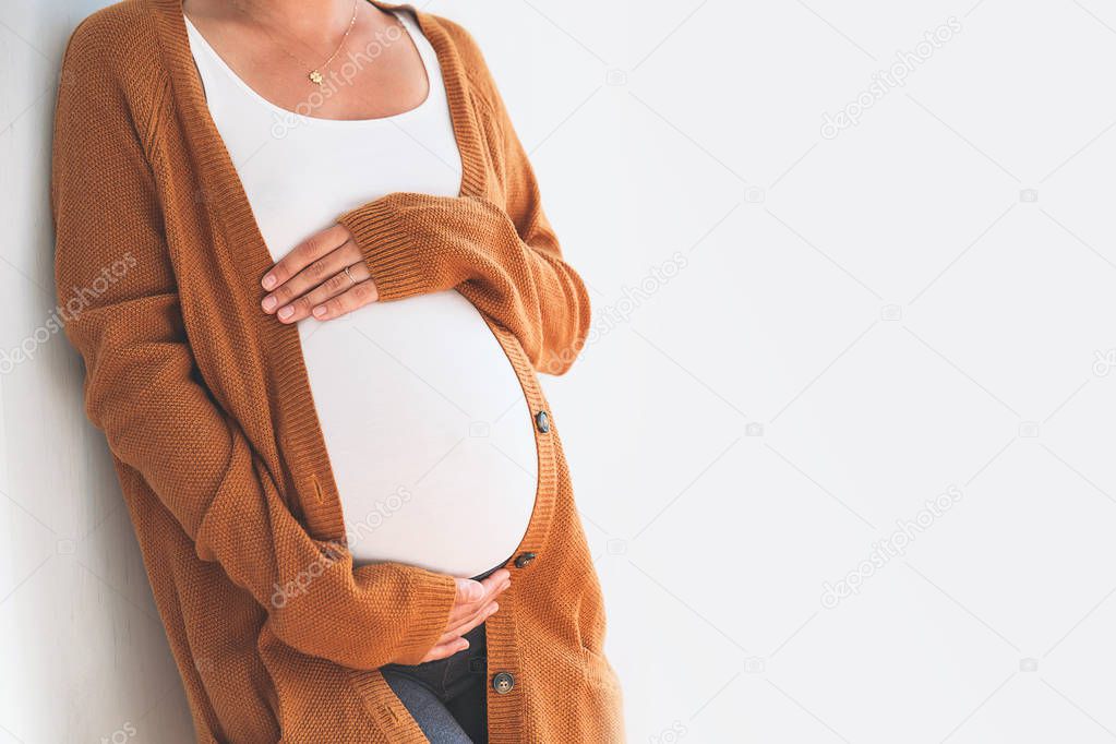 Close-up pregnant woman touching her belly. Mother anticipation 