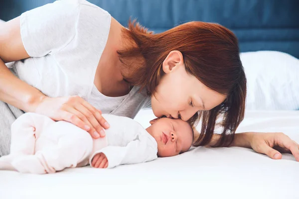 Mamma kysser hennes nyfödda baby. — Stockfoto