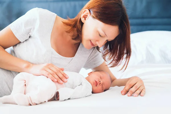 Ung mamma tittar på hennes nyfödda baby. — Stockfoto