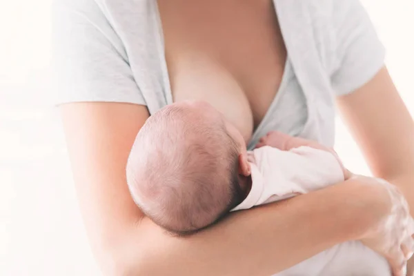 Mãe amamentando bebê recém-nascido em casa . — Fotografia de Stock