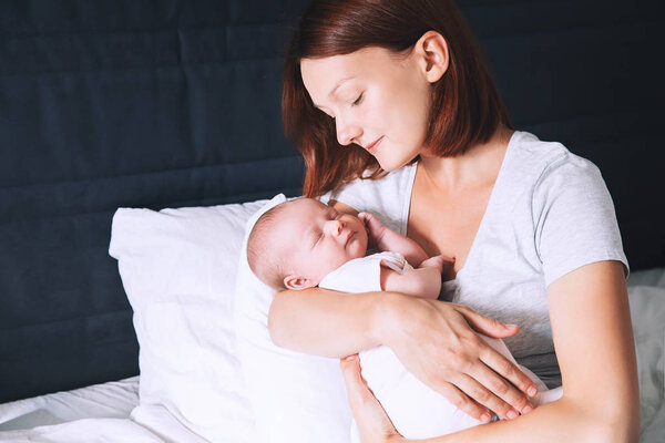 Sleeping baby in hands of his loving mother.