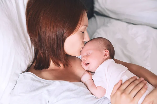 Kissing neki újszülött baba anya. — Stock Fotó
