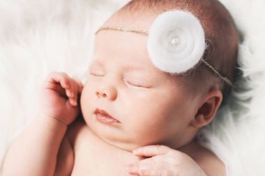 Bir şal üzerinde beyaz battaniye içinde yeni doğmuş bebek uyku.