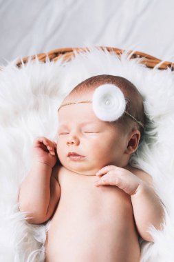 Bir şal üzerinde beyaz battaniye içinde yeni doğmuş bebek uyku.