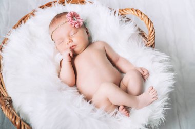 Bir şal üzerinde beyaz battaniye içinde yeni doğmuş bebek uyku.