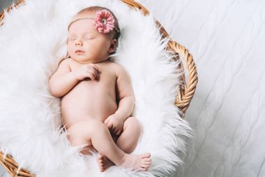Bir şal üzerinde beyaz battaniye içinde yeni doğmuş bebek uyku.