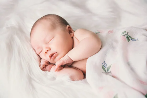 Спящий новорожденный ребенок в обертке на белом одеяле . — стоковое фото