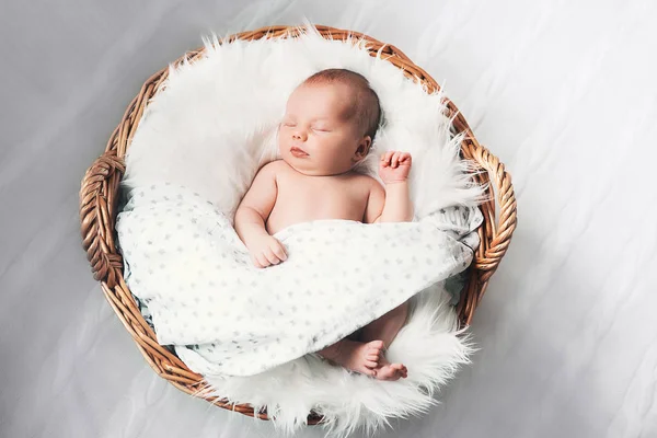 Sleeping newborn baby in a wrap on white blanket. — Stock Photo, Image