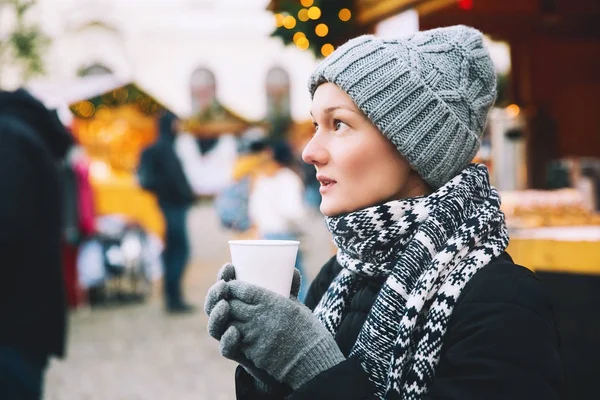 Женщина пьет горячий чай или глинтвейн на Рождество в Европе — стоковое фото