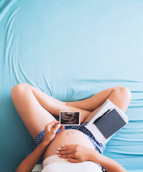Donna incinta prende appunti nel taccuino e tenendo gli ultrasuoni im — Foto Stock