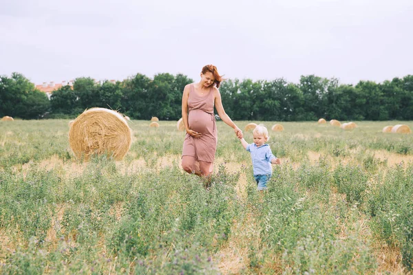 Femme enceinte et fils sur la nature . — Photo