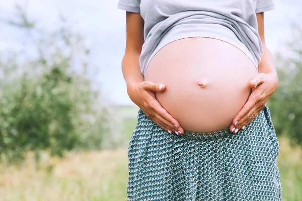 Primo piano della pancia incinta in natura — Foto Stock