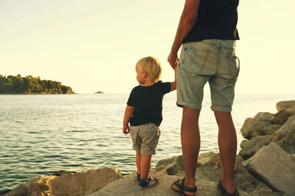 Отец и сын вернулись силуэты прогуливаясь по морю . — стоковое фото