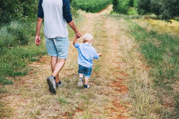 Vader en zoon wandelen met de hond op de natuur, buiten. — Stockfoto