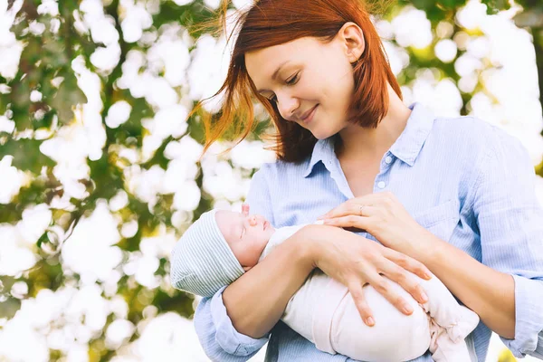 彼女の腕に彼女の生まれたばかりの赤ちゃんとの愛情のある母. — ストック写真