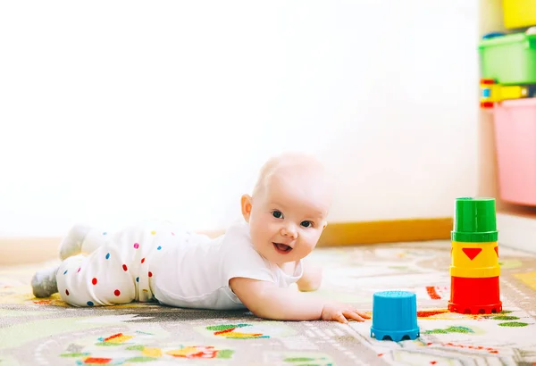 Bebê brincando com brinquedos coloridos em casa . — Fotografia de Stock