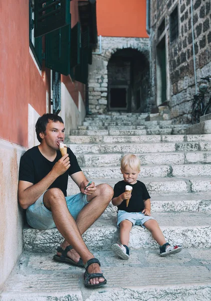 Pai e filho comendo juntos sorvete ao ar livre . — Fotografia de Stock