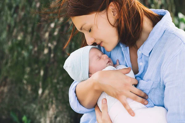 Madre cariñosa con su bebé recién nacido en sus brazos . — Foto de Stock