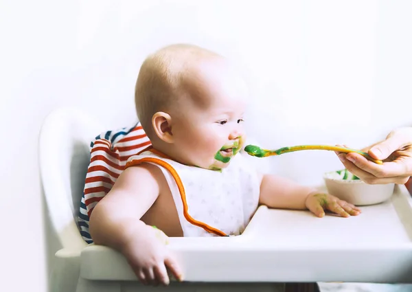 Mãe alimentando pequeno bebê com colher — Fotografia de Stock