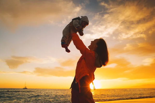 Mutter und Baby Silhouetten bei Sonnenuntergang am Meeresstrand — Stockfoto