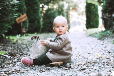 Küçük çocuk doğayla oynuyor. Aile açık havada