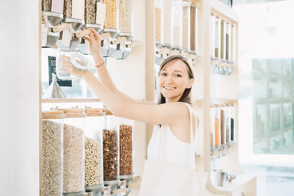 Zero waste shop. Girl buying in sustainable plastic free grocery store