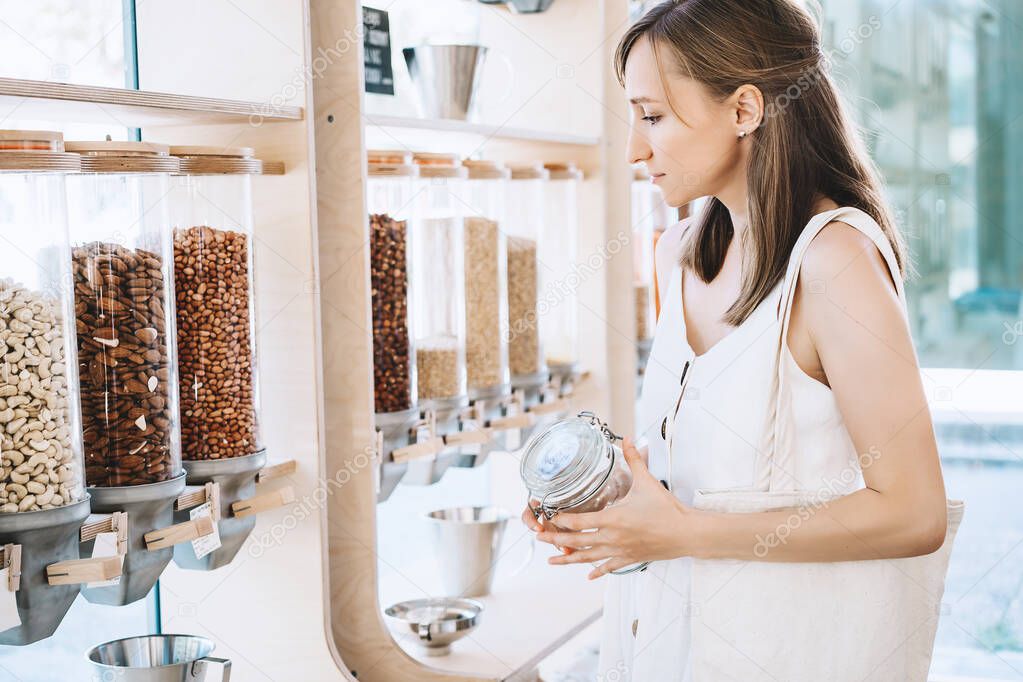 Zero waste shop. Girl buying in sustainable plastic free grocery