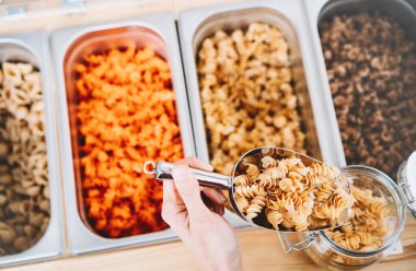 Woman buying pasta in zero waste shop clipart