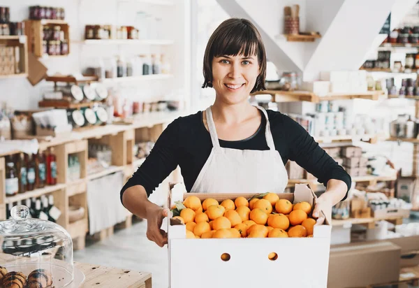 Mulher com caixa de papelão de tangerinas em loja de resíduos zero . — Fotografia de Stock