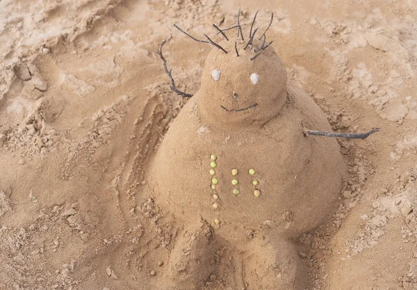 Nouvel An ou Joyeux Noël bonhomme de neige de sable sur la plage de l'océan . — Photo