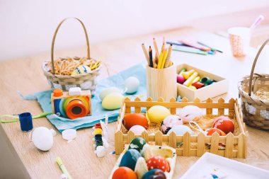 Mutlu Paskalyalar! Yumurta boyamak. Boyalar, keçeli kalemler, tatil için yumurta boyama süslemeleri. Yaratıcı bir geçmiş. Paskalya için hazırlanan çocuklu aile.