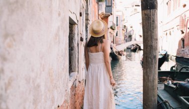 Genç bir kadın İtalya 'ya gidiyor. Avrupa 'da tatil. Kız Venedik 'te güzel manzaranın tadını çıkarıyor. Venezia sokaklarında yürüyen kadın turist. Moda blogcusu Büyük Kanal 'ın manzaralı köprüsünde fotoğraf çekiyor.