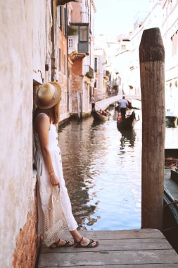 Genç bir kadın İtalya 'ya gidiyor. Avrupa 'da tatil. Kız Venedik 'te güzel manzaranın tadını çıkarıyor. Venezia sokaklarında yürüyen kadın turist. Moda blogcusu Büyük Kanal 'ın manzaralı köprüsünde fotoğraf çekiyor.