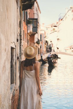 Genç bir kadın İtalya 'ya gidiyor. Avrupa 'da tatil. Kız Venedik 'te güzel manzaranın tadını çıkarıyor. Venezia sokaklarında yürüyen kadın turist. Moda blogcusu Büyük Kanal 'ın manzaralı köprüsünde fotoğraf çekiyor.
