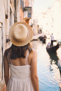 Genç bir kadın İtalya 'ya gidiyor. Avrupa 'da tatil. Kız Venedik 'te güzel manzaranın tadını çıkarıyor. Venezia sokaklarında yürüyen kadın turist. Moda blogcusu Büyük Kanal 'ın manzaralı köprüsünde fotoğraf çekiyor.
