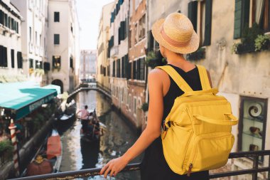Genç bir kadın İtalya 'ya gidiyor. Avrupa 'da tatil. Kız Venedik 'te güzel manzaranın tadını çıkarıyor. Venezia sokaklarında yürüyen kadın turist. Moda blogcusu Büyük Kanal 'ın manzaralı köprüsünde fotoğraf çekiyor.