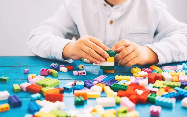 아이들은 장난감 벽돌이나 플라스틱 블록을 건물을 짓습니다 학교나 집이나 교실에서의 — 스톡 사진