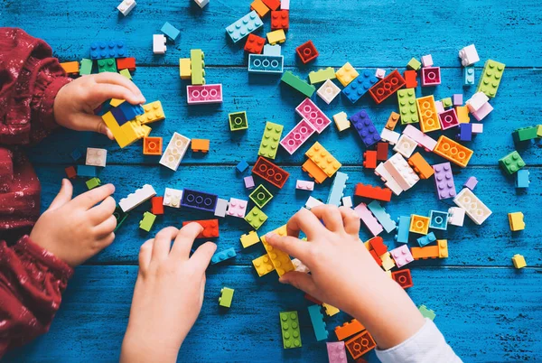 아이들은 놀이를 장난감 벽돌이나 플라스틱 블록을 짓는다 학교나 집이나 교실에서의 — 스톡 사진