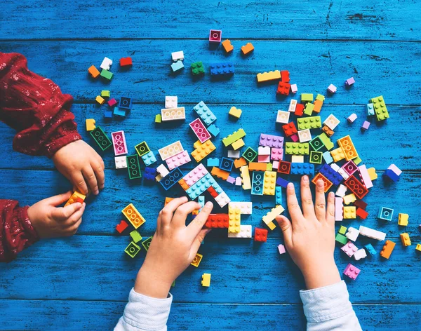 아이들은 놀이를 장난감 벽돌이나 플라스틱 블록을 짓는다 학교나 집이나 교실에서의 — 스톡 사진
