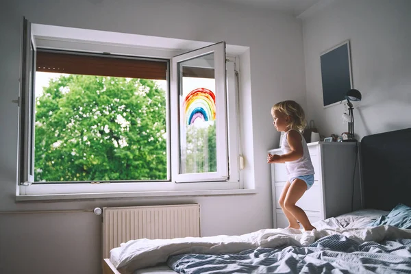 Χαριτωμένο Κοριτσάκι Που Διασκεδάζει Πηδώντας Στο Κρεβάτι Στο Φόντο Του — Φωτογραφία Αρχείου