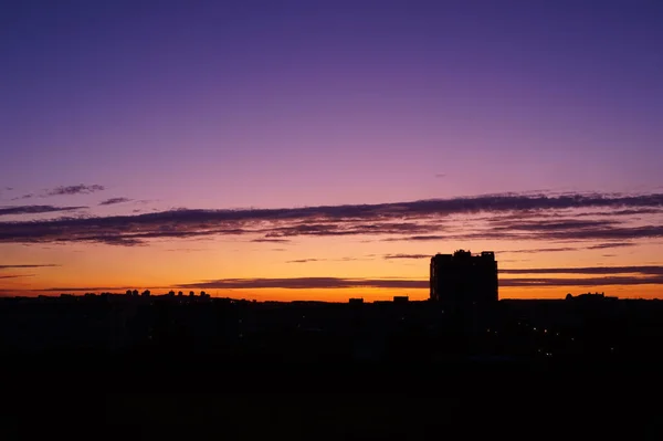 Colorido amanecer sobre la ciudad, hermosas nubes en el cielo — Foto de Stock