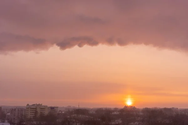 Colorido amanecer sobre la ciudad, sol y hermosas nubes en el cielo — Foto de Stock