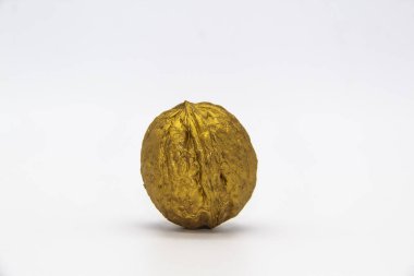 A golden walnut on a white background