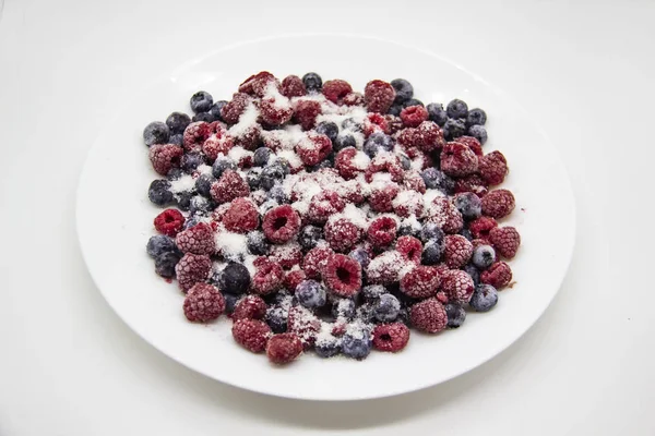 白盘上的冰冻覆盆子和蓝莓中混合着一种浆果糖 一个糖霜伯里斯 一个甜的背景与冰冻的覆盆子和蓝莓 — 图库照片