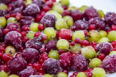 Dondurucudaki dondurulmuş meyveler. Donmuş kirazlı, üzümlü ve üzümlü bir arka plan. Sağlıklı dut karışımı.