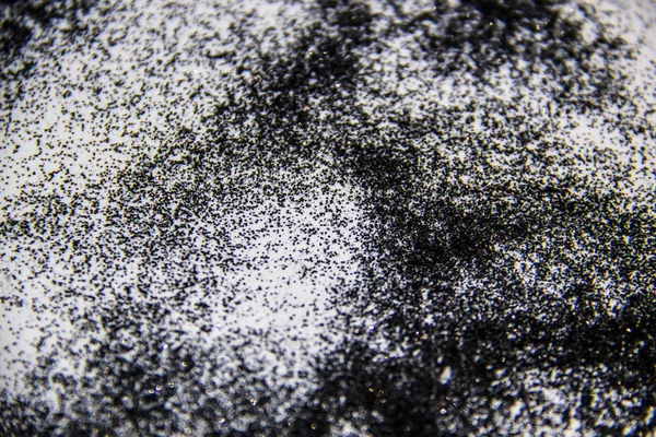 A black glitter on the white background
