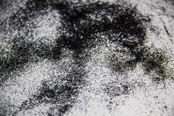 A black glitter on the white background