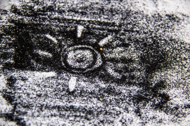 Beyaz arka planda siyah bir parıltı. Siyah kumla boyanmış güneş